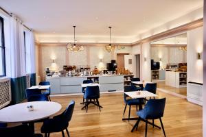a restaurant with tables and chairs and a kitchen at Hotel de la Bourse, Mulhouse Gare, Sure Hotel Collection by Best Western in Mulhouse