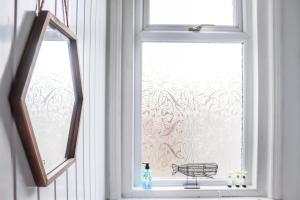 une fenêtre avec une bouteille de détergent sur le rebord de la fenêtre dans l'établissement 3 BDR Entire Home Sleeps Up to 5 Contractors & Families Long or Short Stay Free WiFi & Parking, à Lynemouth 35 autres photos