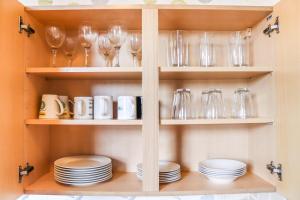 un placard avec des assiettes, des verres et de la vaisselle dans l'établissement 3 BDR Entire Home Sleeps Up to 5 Contractors & Families Long or Short Stay Free WiFi & Parking, à Lynemouth