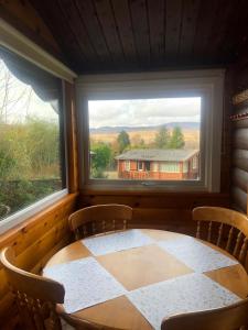 a table and chairs in a room with a window at Misty Mountain Log Cabin - Trawsfynydd in Trawsfynydd