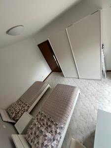 an attic bedroom with two beds and a cabinet at Locazione Turistica Mario Colucci in Verona