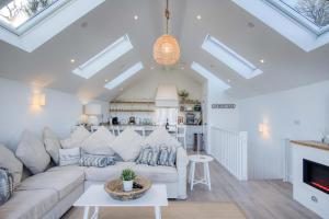 Ty Florence - 3 Bedroom Cottage - Bayview Oxwich في أوكسويتش: غرفة معيشة مع أريكة بيضاء ومدفأة