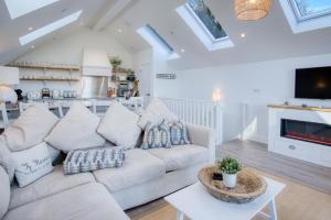 Ty Florence - 3 Bedroom Cottage - Bayview Oxwich في أوكسويتش: غرفة معيشة مع أريكة بيضاء ومدفأة