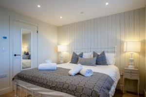 Ty Florence - 3 Bedroom Cottage - Bayview Oxwich في أوكسويتش: غرفة نوم بسرير كبير مع وسائد زرقاء