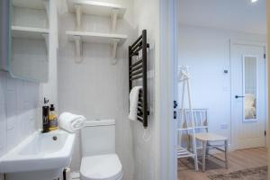 Ty Florence - 3 Bedroom Cottage - Bayview Oxwich في أوكسويتش: حمام أبيض مع مرحاض ومغسلة +46 صورة