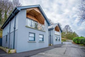 Ty Florence - 3 Bedroom Cottage - Bayview Oxwich في أوكسويتش: بيت ابيض بسقف مقامر