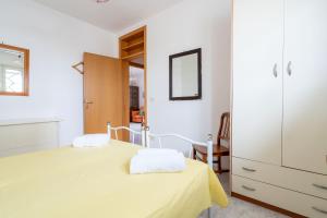a white room with a bed and a mirror at L'Attico di Romolo a 150 mt dal mare in San Pietro in Bevagna
