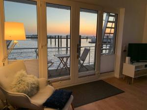 een woonkamer met uitzicht op het water bij Hausboot Maritim Holiday in Großenbrode