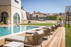 a row of tables and chairs next to a swimming pool at Villa The Boutique Cappadocia in Urgup
