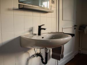 a white sink in a bathroom with a mirror at Ferienhaus Hallmanns Hof in Schmallenberg +35 photos