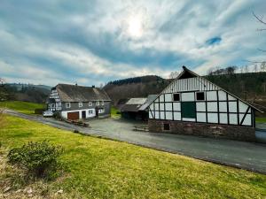 a group of buildings in a field with a grass field at Ferienhaus Hallmanns Hof in Schmallenberg