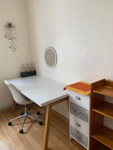 einen weißen Schreibtisch mit einem Spiegel an der Wand in der Unterkunft Chambre chez l'HABITANT appartement partagé sauf salon in Angers