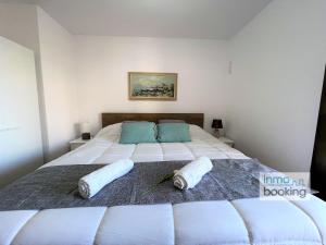 Un dormitorio con una cama grande con dos almohadas encima. en Paradis Sant Sebastian , climatizado y con piscina, en Salou 40 fotos más