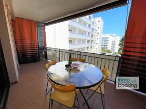 Una mesa y sillas en un balcón con ventana. en Paradis Sant Sebastian , climatizado y con piscina, en Salou