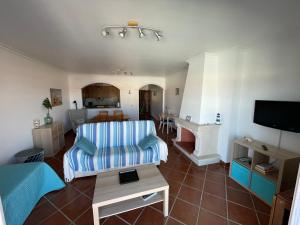 a living room with a couch and a tv at Ericeira Beach House in Ericeira