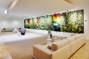 a living room with a large colorful painting on the wall at Barceló Bilbao Nervión in Bilbao