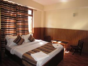 a hotel room with a bed and a window at KG Tusheta - 200 mtrs from MG Marg in Gangtok