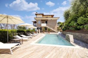 una piscina con sedie a sdraio e una casa di Residenza Marano a Cupra Marittima