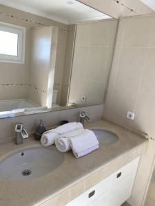 a bathroom with a sink with towels and a mirror at Villa Loma Beach in Chiclana de la Frontera +9 photos