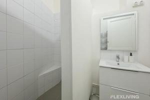 Un baño blanco con lavabo y espejo. en Flexliving - Room - Henri Sellier - Suresnes 92, en Suresnes