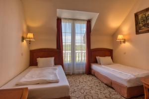 Łóżko lub łóżka w pokoju w obiekcie Hotel Bellevue Esztergom