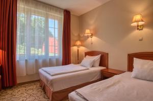 Łóżko lub łóżka w pokoju w obiekcie Hotel Bellevue Esztergom