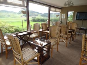 ein Esszimmer mit Tisch und Stühlen und einem großen Fenster in der Unterkunft Laggan Hotel in Laggan