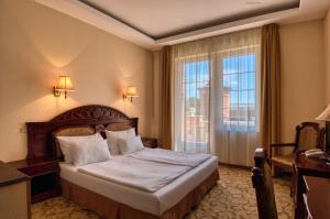 pokój hotelowy z łóżkiem i oknem w obiekcie Hotel Bellevue Esztergom w mieście Ostrzyhom