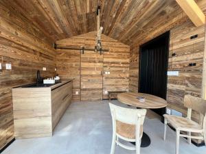 a kitchen with wooden walls and a table and chairs at Domček pri studenom potoku in Nižná