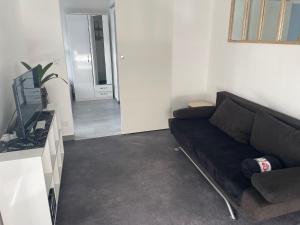 a living room with a couch and a television at Les embruns in Saint-Jean-de-Monts