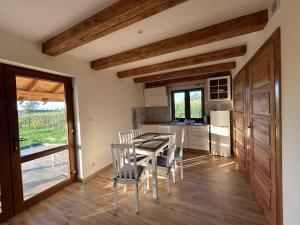 a kitchen and dining room with a table and chairs at Domek Sosenka in Czarnówka