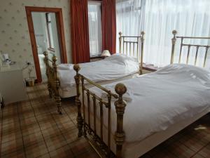 ein Schlafzimmer mit zwei Betten und einem Spiegel in der Unterkunft Laggan Hotel in Laggan