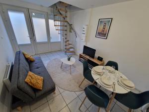 a living room with a couch and a table and chairs at Duplex tout équipé in Marpent