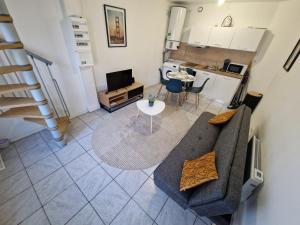 a living room with a couch and a table and a kitchen at Duplex tout équipé in Marpent