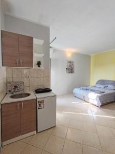 Una cocina con fregadero y una cama en una habitación. en Altura Rooms & Apartments, en Neum