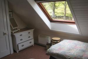 a attic bedroom with a bed and a window at The Old School House in Carbost +22 photos