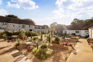 un jardin extérieur avec tables, chaises et plantes en pot dans l'établissement The Hayloft, Sewerby, Bridlington, Wi-Fi & Parking, à Bridlington