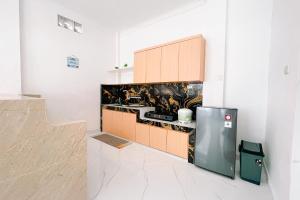 a kitchen with a sink and a refrigerator in a room at Simangande View & Resto by Staigo in Ambarita +30 photos