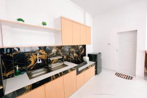 a kitchen with a sink and a counter at Simangande View & Resto by Staigo in Ambarita