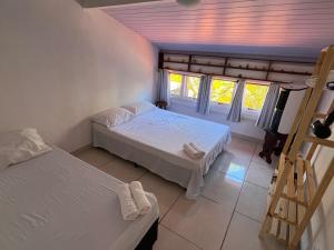 um quarto com duas camas, uma escada e janelas em EXCELENTE CASA EM CABO FRIO - BRAGA em Cabo Frio
