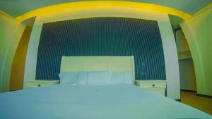 a bedroom with a white bed with a yellow and green wall at Chebera Elephant Paw Lodge in Bokdē +203 photos