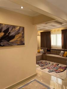 a living room with a couch and a painting on the wall at شقه مفروشه كامله in Ṭalkha