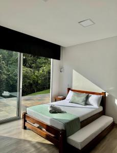 a bedroom with a bed and a large window at Casa campestre en el Eje Cafetero in Circasia +28 photos
