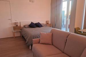 a living room with a bed and a couch at Cozy flat for Vacation& business in Famagosta area in Milan +16 photos