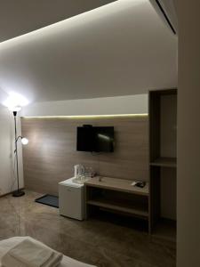 a room with a bed and a tv on a wall at La Mirage in Šabac