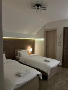 a hotel room with two beds with towels on them at La Mirage in Šabac