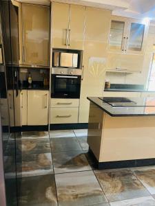 a kitchen with stainless steel appliances and glass cabinets at Laicah House in Tlokweng