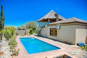 a house with a swimming pool in front of a house at Laicah House in Tlokweng
