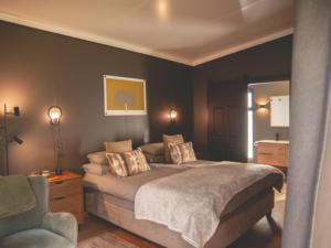 a bedroom with a large bed and a chair at Croxley Farm in Robertson