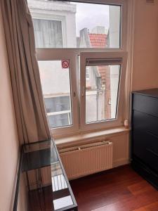 a room with two windows and a spiral staircase at Central B&B Apartment in Amsterdam in Amsterdam